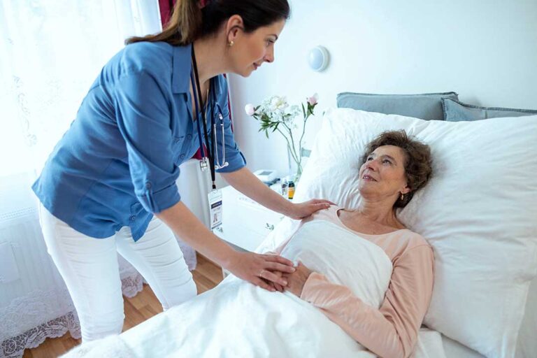 Family members review care documents with an assisted living staff member at a resident’s table.